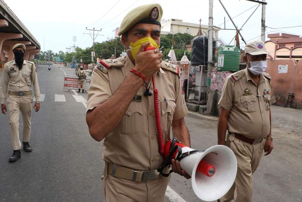 कोरोना वायरस के प्रसार को रोकने के लिए लगाए गए लॉकडाउन के दौरान जम्मू के एक इलाके में गश्त करते पुलिसकर्मी