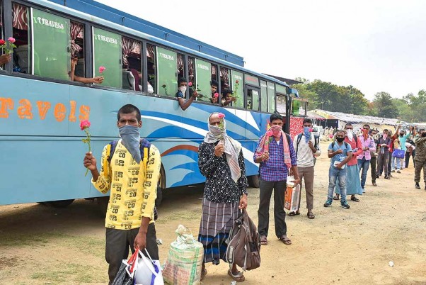 कोरोना के मद्देनजर लगाए गए लॉकडाउन के बीच केरल से धनबाद पहुंचे प्रवासी मजदूर अपने घर तक पहुंचने के लिए कतार में खड़े होकर बसों का इंतजार करते
