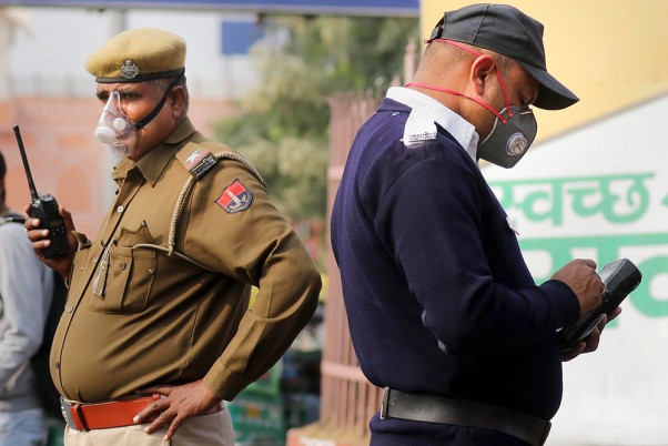 कोरोनो वायरस से बचाव के लिए मास्क पहनकर जयपुर में रेलवे स्टेशन के पास खड़े पुलिस कर्मी