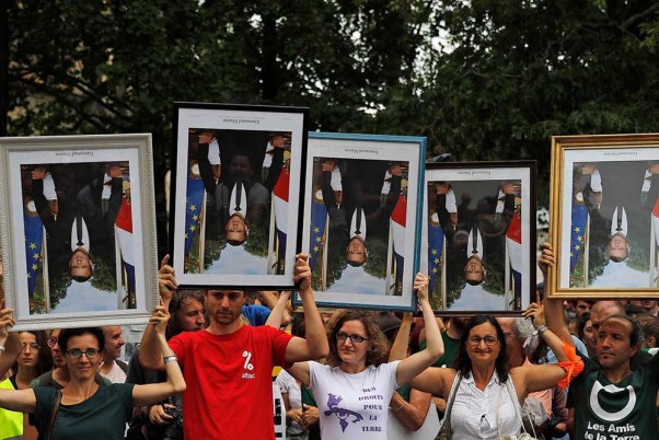 फ्रांस के बेयोन में फ्रांसीसी राष्ट्रपति इमैनुएल मैक्रॉन के चित्रों को उल्टा रख प्रदर्शन करते एक्टिविस्ट