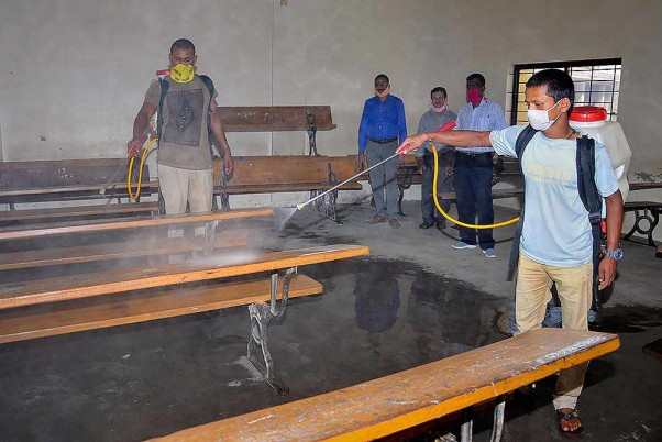 कर्नाटक के चिकमगलूर शहर में आगामी परीक्षाओं से पहले कक्षाओं को सेनिटाइज करते कर्मचारी