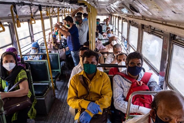 कोरोना वायरस महामारी के मद्देनजर लगाए गए राष्ट्रव्यापी बंद के दौरान एक विशेष बस में यात्रा करते आवश्यक सेवाओं के कर्मचारी