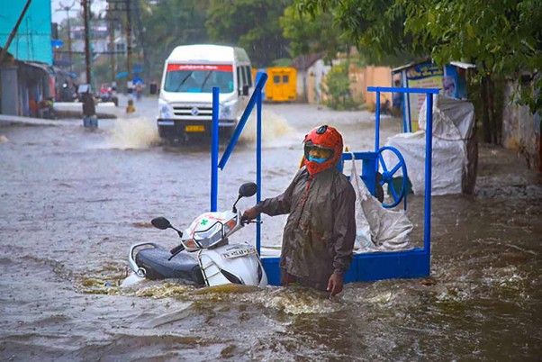 कन्याकुमारी जिले के नैपेरविले में लॉकडाउन के दौरान भारी बारिश के बाद बाढ़ के पानी में अपने वाहन के साथ सड़क पर फंसा यात्री
