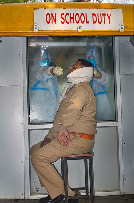 कोरोना वायरस के मद्देनजर मुरादाबाद में कोविड-19 टेस्ट के लिए एक पुलिसकर्मी के स्वाब का नमूना एकत्र करते स्वास्थ्यकर्मी