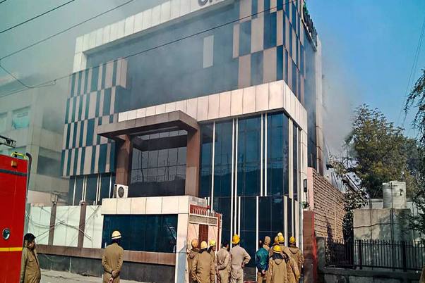 दिल्ली के पीरागढ़ी की एक फैक्ट्री में आग लगने की सूचना पर दमकलकर्मी मौके पर पहुंचे, घटना में 13 दमकलकर्मियों सहित 14 लोग घायल हो गए