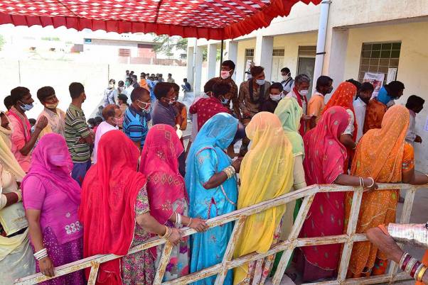 राजस्थान में पंचायत चुनाव के चौथे और आखिरी चरण के दौरान बीकानेर जिले के उदासर गांव में वोट डालने के लिए कतार में खड़े ग्रामीण