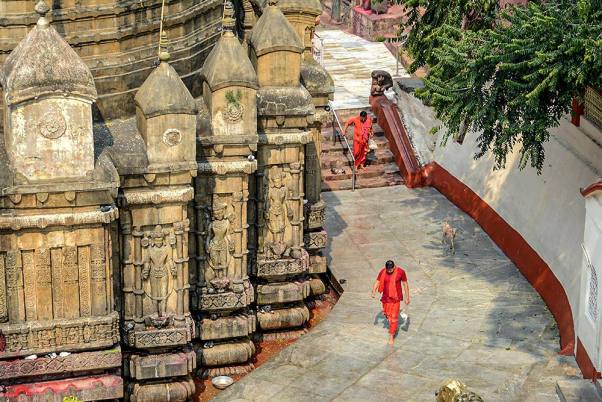 कोरोना वायरस महामारी के मद्देनजर गुवाहाटी स्थित कामाख्या मंदिर के खाली परिसर के अंदर पैदल चलते साधु