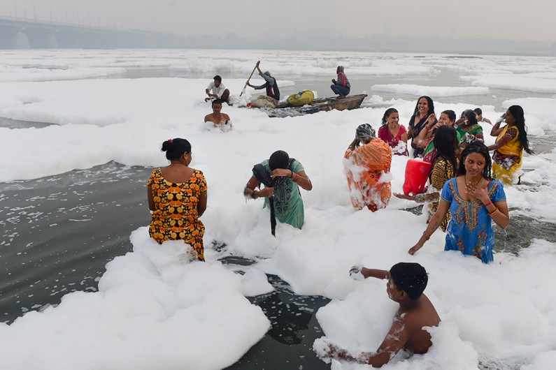 छठ पूजा के पहले दिन दिल्ली की यमुना नदी में जहरीले झाग के बीच श्रद्धालुओं ने किया स्नान