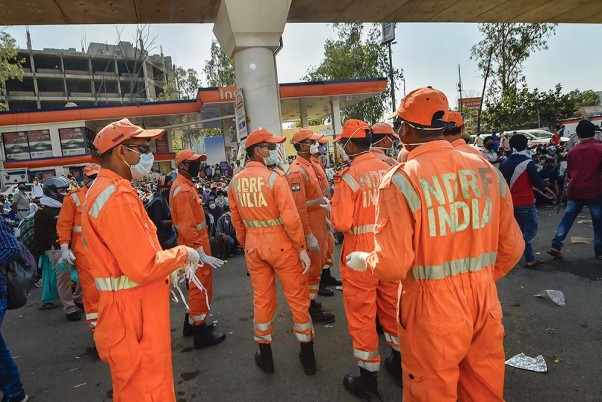 लॉकडाउन के बीच दिल्ली-यूपी बॉडर के पास प्रवासी श्रमिकों की मदद करती एनडीआरएफ की टीम