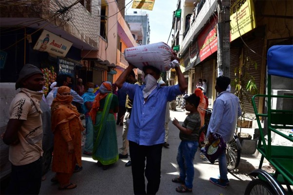 कोरोना वायरस के चलते देशभर में लगाए गए लॉकडाउन के दौरान दिल्ली के विश्वास नगर में स्थित सरकारी राशन की दुकान से राशन इकट्ठा कर ले जाता व्यक्ति