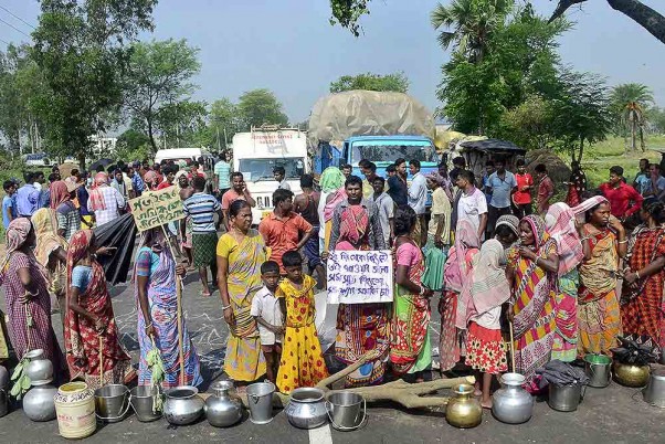 मालदा के गजोल में पीने के पानी और बिजली सेवाओं की नियमित आपूर्ति की मांग करते हुए स्थानीय लोगों ने सड़क पर लगाया जाम।