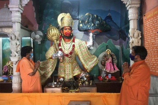 कोरोना वायरस के खिलाफ एहतियात के रूप में मेरठ रोड स्थित मंदिर में मास्क पहनकर प्रार्थना करता एक भक्त