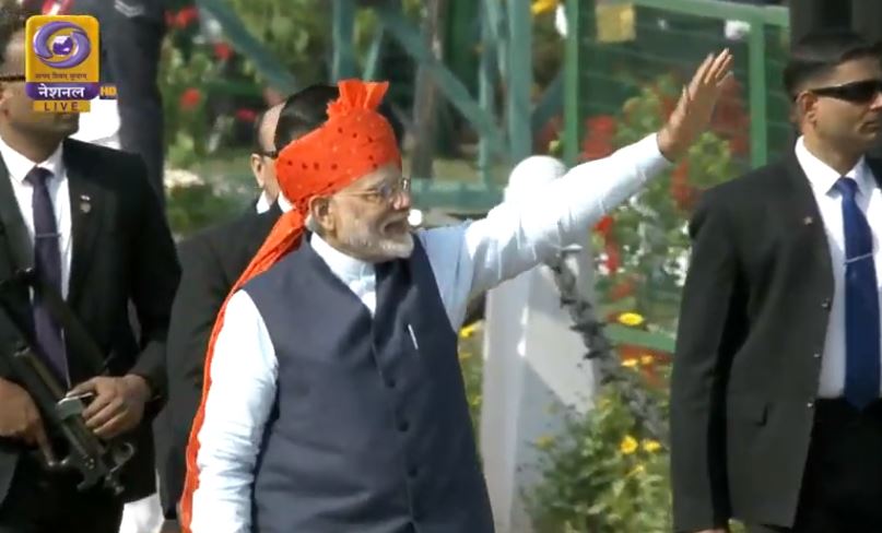 परेड समापन के बाद राजपथ से जाते समय दोनों किनारों पर बैठे लोगों का हाथ हिलाकर कर अभिवादन करते प्रधानमंत्री नरेंद्र मोदी
