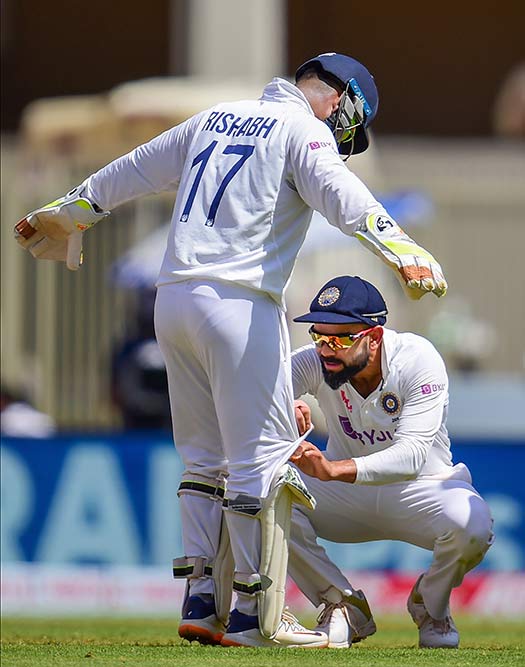 चौथे टेस्ट मैच के बीच विकेट कीपर आर पंत का पैड ठीक करते कप्तान विराट कोहली