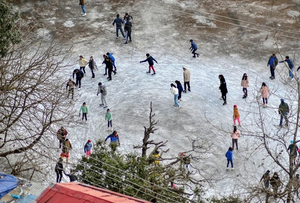 शिमला में बर्फबारी के बाद आइस स्केटिंग का आनंद लेते पर्यटक और स्थानीय लोग