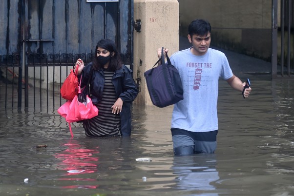 मुंबई में बारिश के बाद जलभराव वाली सड़कों से गुजरने को लोग मजबूर