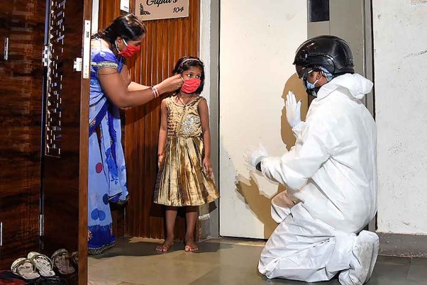 मुंबई में अनलॉक 2.0 के दौरान कोरोना वायरस वायरस महामारी के मद्देनजर डिंडोशी के निवासियों की थर्मल स्क्रीनिंग करता स्वास्थ्यकर्मी