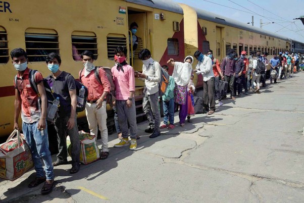 लॉकडाउन के दौरान बेंगलुरु से विशेष ट्रेन द्वारा पटना पहुंचने के बाद दानापुर रेलवे स्टेशन पर कतार में खड़े प्रवासी श्रमिक