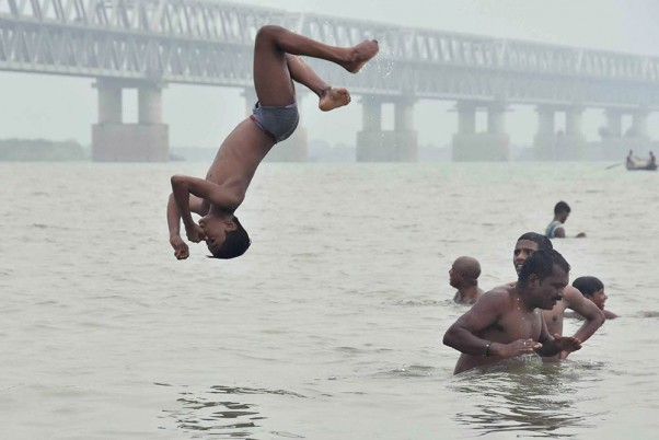 तपती गर्मी के बीच पटना में गंगा नदी में डुबकी लगाते हुए बच्चे
