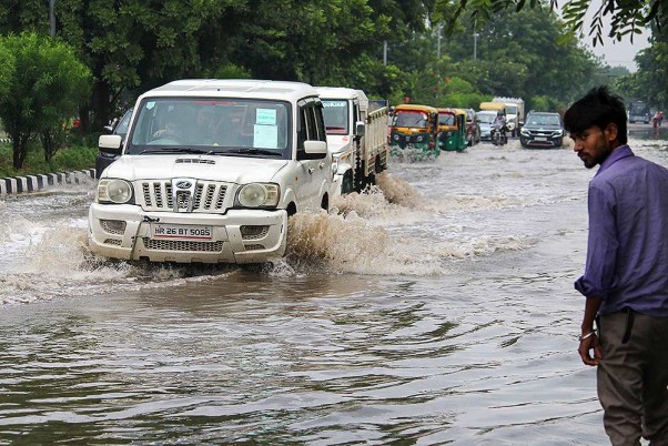गुरुग्राम में तेज बारिश के बाद जलभराव वाली सड़कों पर गुजरते वाहन