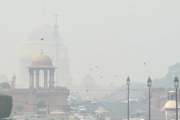 नई दिल्ली में स्मॉग के कारण कम दृश्यता के बीच राजपथ पर वाहनों की कतारें