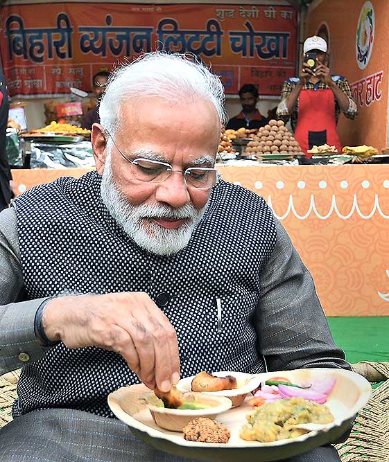 राजधानी दिल्ली में राजपथ पर 'हुनर हाट' में एक स्नैक्स स्टाल पर 'लिट्टी-चोखा' खाते प्रधानमंत्री नरेंद्र मोदी