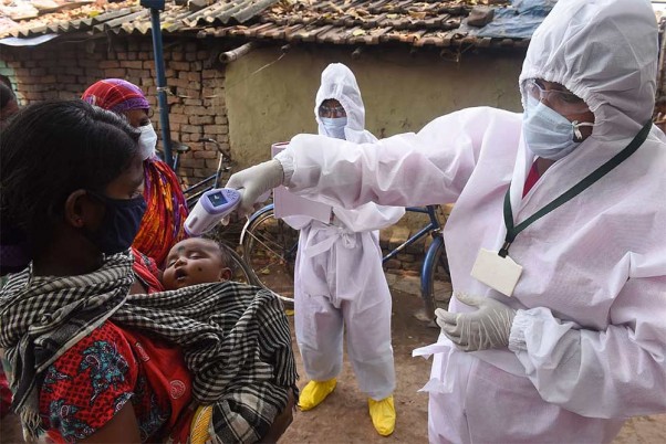 कोरोना वायरस महामारी के मद्देनजर लॉकडाउन के बीच पश्चिम बंगाल के उत्तरपारा-कोटरुंग नगर पालिका में बच्चे का तापमान जांचता स्वास्थ्यकर्मी
