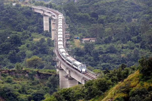 जम्मू में कटरा की ओर एक रेल पुल से गुजरती ‘वंदे भारत एक्सप्रेस’ ट्रेन