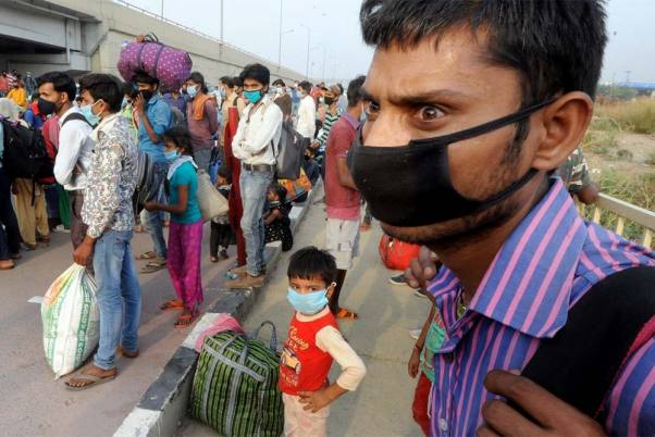 राजधानी दिल्ली में लॉकडाउन के बीच गाजीपुर बॉर्डर के पास अपने मूल स्थानों तक पहुंचने के लिए बसों का इतंजार करते प्रवासी श्रमिक