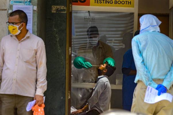 राजधानी दिल्ली में चल रहे लॉकडाउन के दौरान सरकारी अस्पताल में संदिग्ध कोविड-19 मरीजों की जांच करते स्वास्थ्यकर्मी