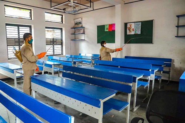 लॉकडाउन के दौरान कोझीकोड के एक स्कूल में परीक्षा के बाद कक्षा के अंदर कीटाणुनाशक का छिड़काव करते कर्मचारी