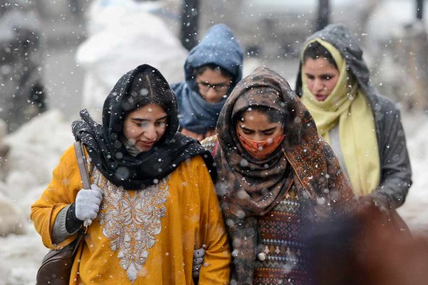 श्रीनगर में हल्की बर्फबारी के दौरान जारी लोगों का काम