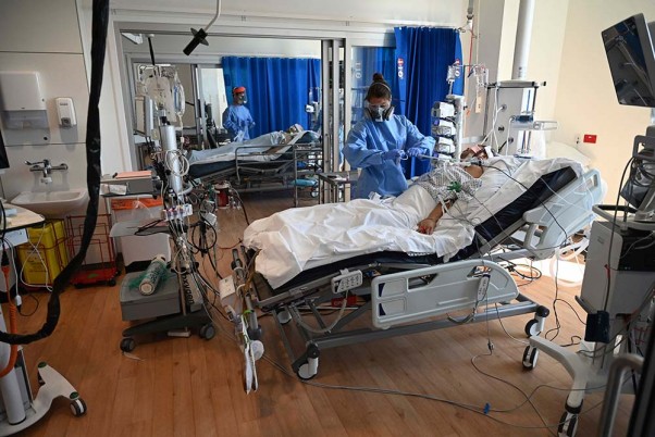 इंग्लैंड के कैम्ब्रिज में रॉयल पापवर्थ अस्पताल के आईसीयू में पीपीई किट पहनकर कोरोना मरीजों का इलाज करता मेडिकल स्टाफ