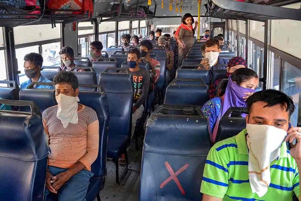 पंजाब सरकार द्वारा सार्वजनिक परिवहन सेवाओं को फिर से शुरू करने के बाद अमृतसर में बस में यात्रा करते लोग