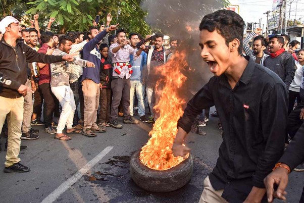 गुवाहाटी में नागरिकता संशोधन विधेयक के विरोध के दौरान टायर जलाते ऑल असम स्टूडेंट्स यूनियन और नॉर्थ ईस्ट स्टूडेंट्स ऑर्गनाइजेशन के प्रदर्शनकारी