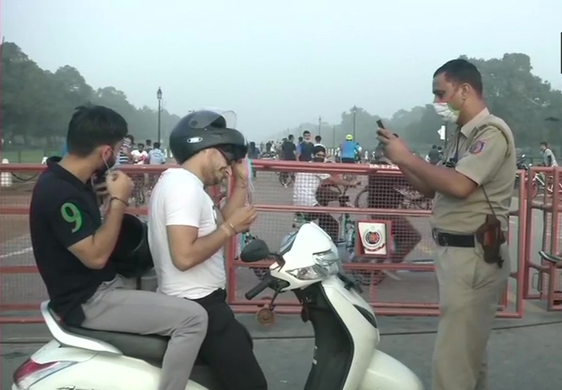 कोविड-19: बिना मास्क पहने यात्रा कर रहे लोगों का चालान काटती दिल्ली पुलिस
