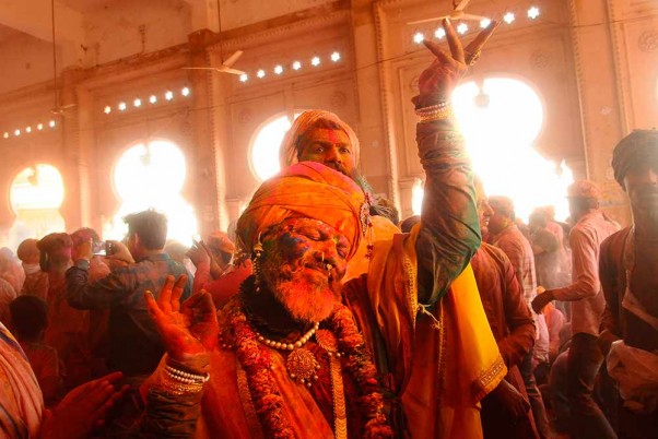 लठमार होली उत्सव समारोह में कृष्ण की भक्ति में रंगों से होली खेलते और डांस करते भक्त