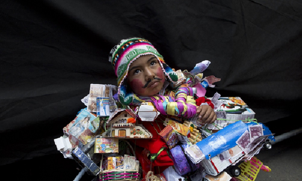 बोलीविया के ला पाज में यहां के पारंपरिक देवता ‘एकेको’ के रूप में तैयार एक बच्चा