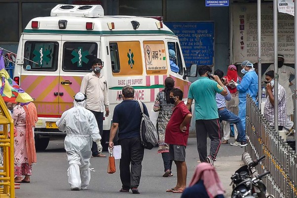 राजधानी दिल्ली में लॉकडाउन के दौरान एम्स में कोविड-19 के संदिग्ध मरीजों के साथ पीपीई किट पहने हुए स्वास्थ्यकर्मी