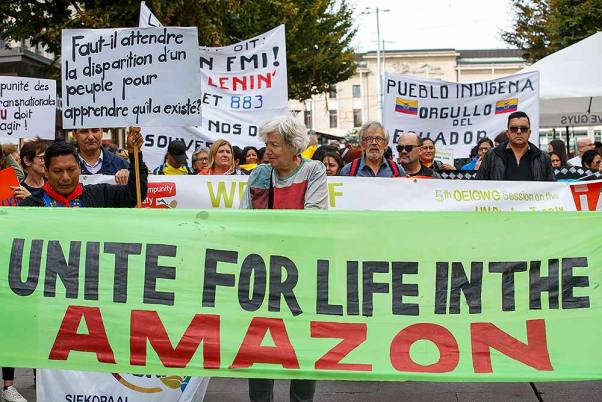 स्विट्जरलैंड के जिनेवा में क्लाइमेट जस्टिस के लिए एक रैली के दौरान विरोध प्रदर्शन करते अमेजन के स्थानीय लोग