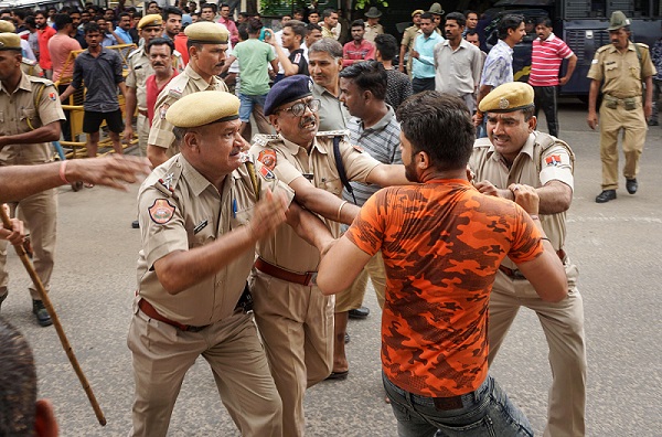 जयपुर के शास्त्री नगर इलाके में नाबालिग से हुए बलात्कार के खिलाफ प्रदर्शन कर रहे लोगों को हिरासत में लेती पुलिस