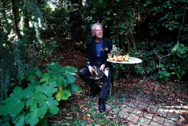 पेरिस के पास चैविल में अपने घर के बगीचे में एक तस्वीर के लिए पोज देते ऑस्ट्रियाई लेखक पीटर हैंडके