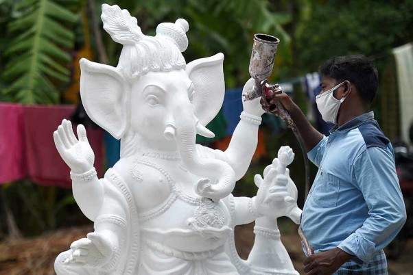 चेन्नई के बाहरी इलाके में गणेश चतुर्थी त्योहार से पहले भगवान गणेश की मूर्ति को तैयार करता कारीगर