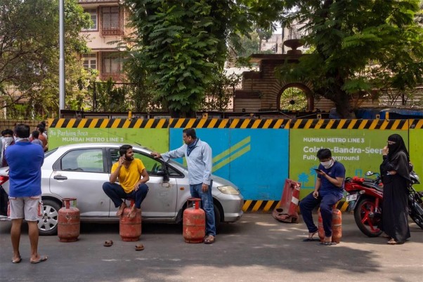 कोरोना वायरस महामारी के मद्देनजर देशव्यापी तालाबंदी के दौरान मुंबई में रसोई गैस सिलेंडर लेने के लिए सोशल डिस्टेंसिंग का ध्यान रखते हुए लाइन में खड़े लोग