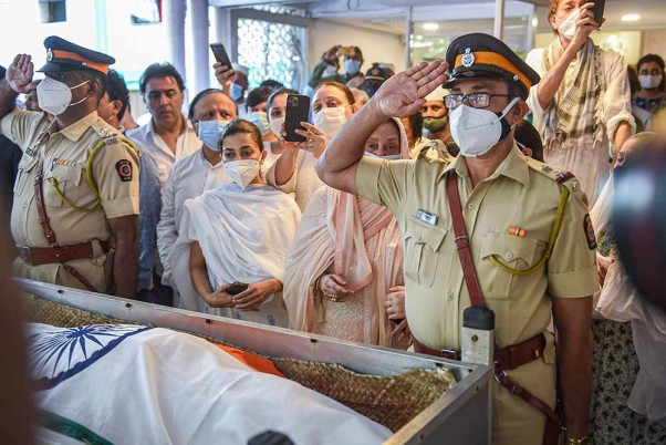 मुंबई में बॉलीवुड के दिग्गज अभिनेता दिलीप कुमार के अंतिम संस्कार के लिए गार्ड ऑफ ऑनर के दौरान सलामी देते पुलिसकर्मी