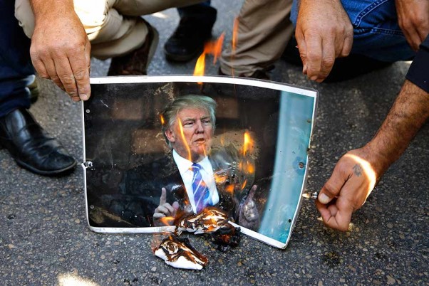 लेबनान में अमेरिकी दूतावास के बाहर अमेरिकी राष्ट्रपति डोनाल्ड ट्रम्प के विरोध में उनका पोस्टर जलाते प्रदर्शनकारी