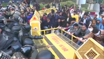 CAA के विरोध में संसद मार्च के दौरान बैरिकेडिंग को तोड़ते जामिया के छात्र