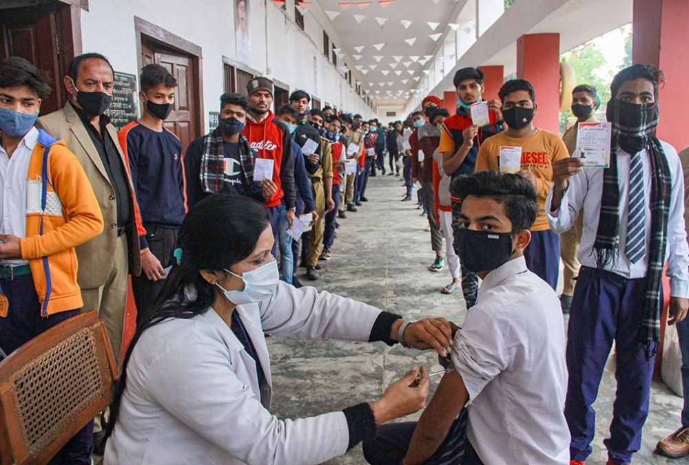 मुरादाबाद के एक स्कूल में छात्रों को कोरोना वैक्सीन लगाती स्वास्थ्य कार्यकर्ता