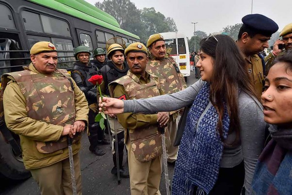 नई दिल्ली में जंतर मंतर पर नागरिकता (संशोधन) अधिनियम के खिलाफ प्रदर्शन के दौरान पुलिसकर्मियों को गुलाब देती एक प्रदर्शनकारी