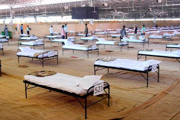 नागपुर में जारी लॉकडाउन के दौरान नागपुर महानगर पालिका (एनएमसी) के कोविड केयर सेंटर में कोरोना मरीजों के बेड लगाते कार्यकर्ता